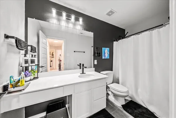 a bathroom with a sink a toilet and a mirror