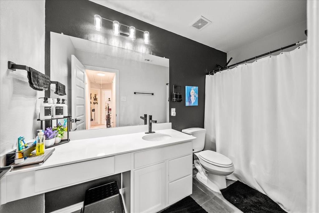 1908 Twisted Tree Lane Mesquite, TX 75149 - Photo 13 of 22 Full bathroom with vanity, a shower with shower curtain, and dark tile patterned flooring