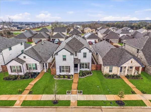 an aerial view of residential houses with yard and mountain view in back