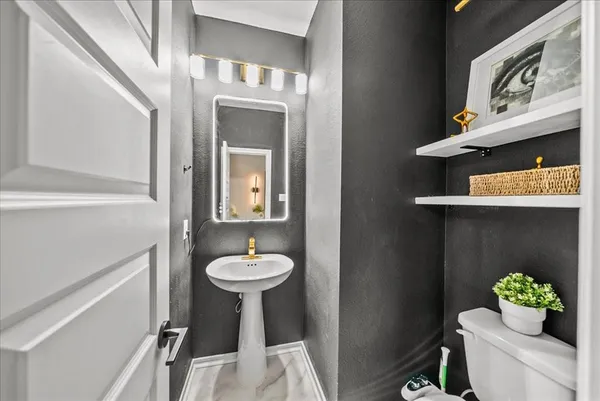 a bathroom with a sink mirror and toilet