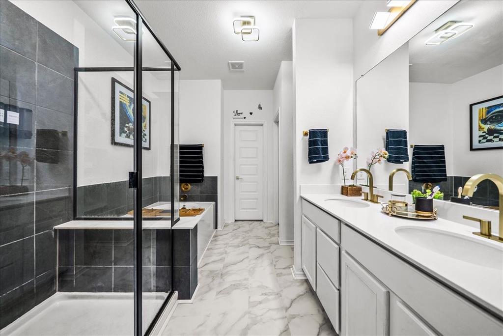 1908 Twisted Tree Lane Mesquite, TX 75149 - Photo 9 of 22 Bathroom featuring a garden tub, double vanity, a stall shower, light marble finish floors, and a towel warmer