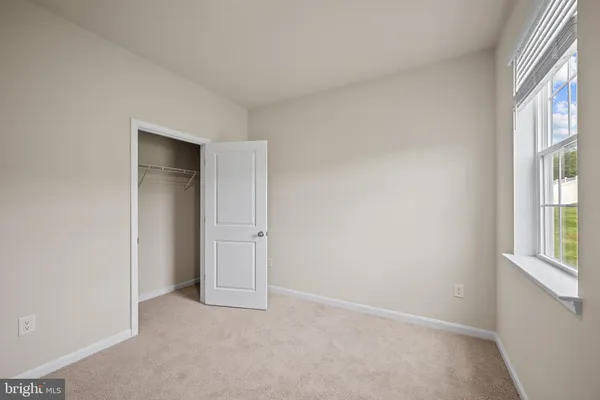 an empty room with windows and closet