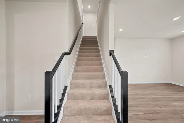a view of staircase with wooden floor and white walls