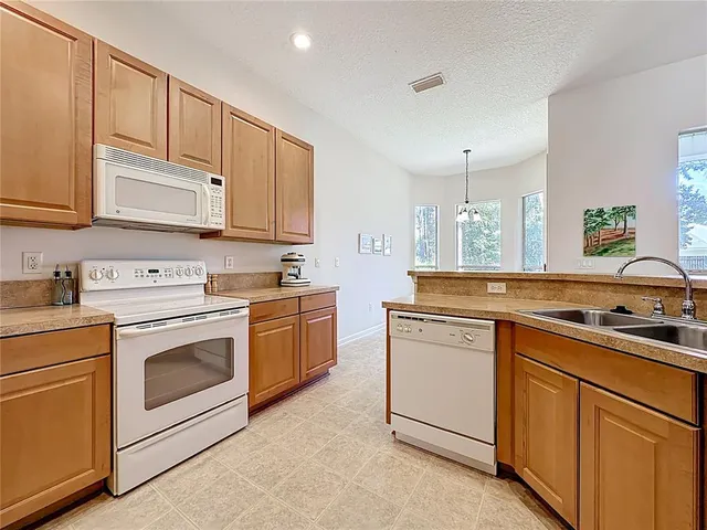 a kitchen with granite countertop white cabinets and white appliances