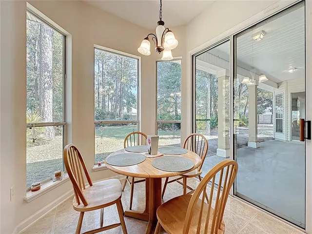 a dining room with furniture large windows and wooden floor