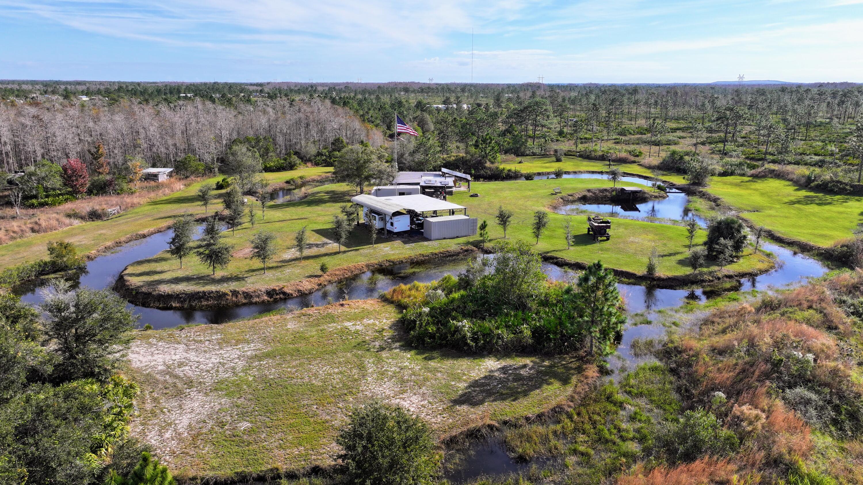1224001 Holopaw Groves Rd Street St. Cloud, FL 34773 - Photo 1 of 99 a aerial view of a house with a garden and lake view