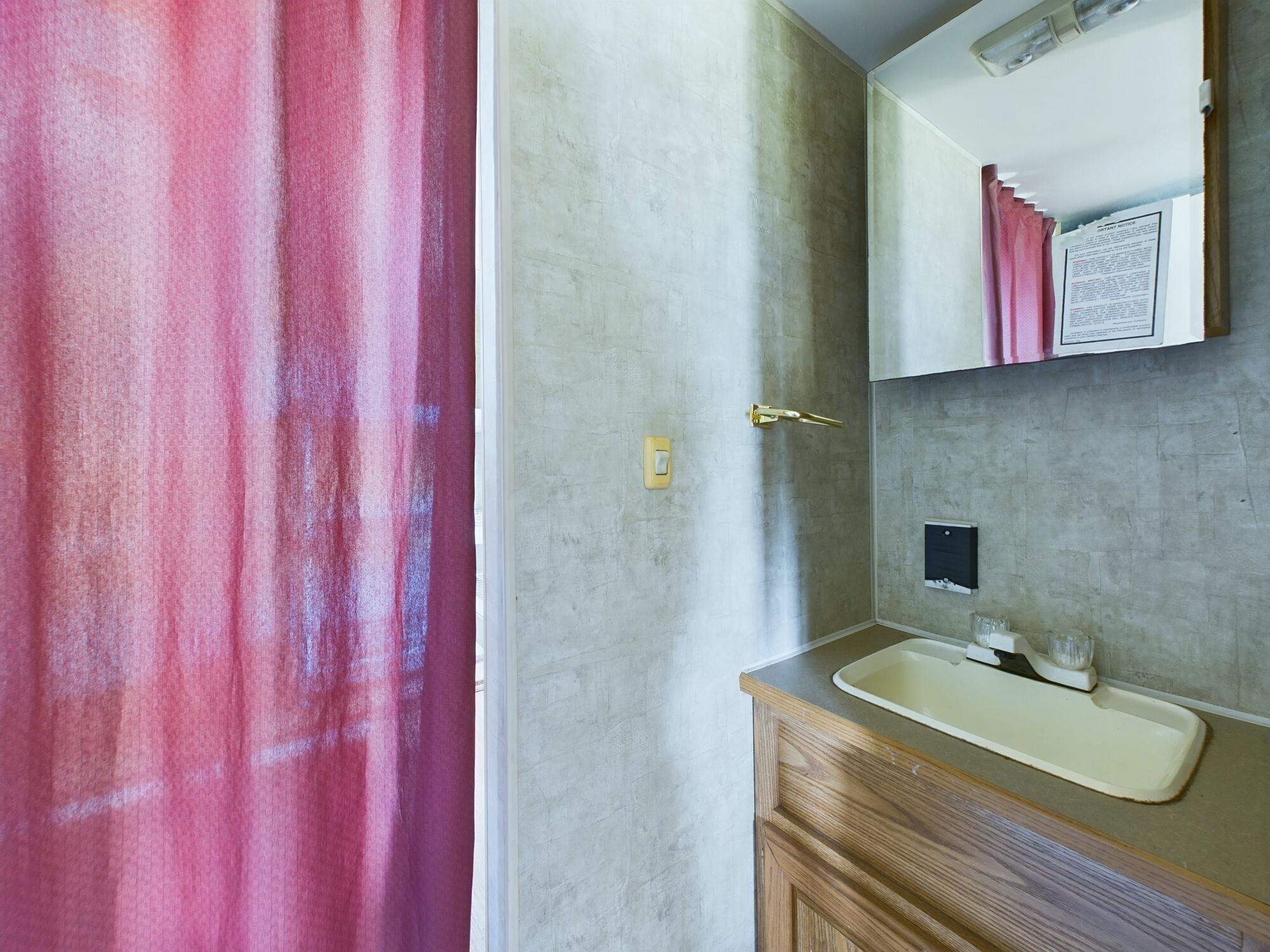 1224001 Holopaw Groves Rd Street St. Cloud, FL 34773 - Photo 29 of 99 a bathroom with a sink vanity and mirror