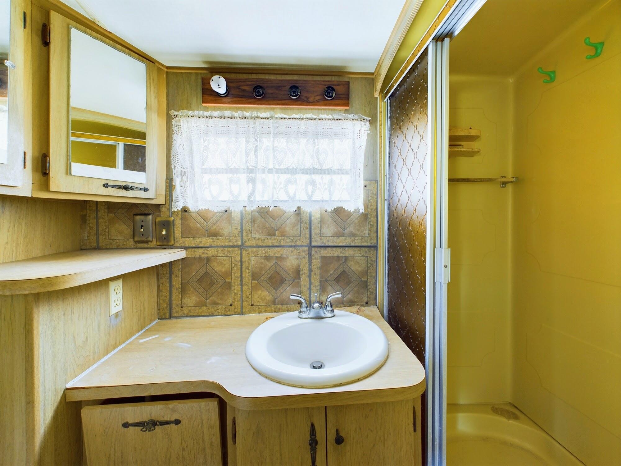 1224001 Holopaw Groves Rd Street St. Cloud, FL 34773 - Photo 49 of 99 a bathroom with a sink and a mirror