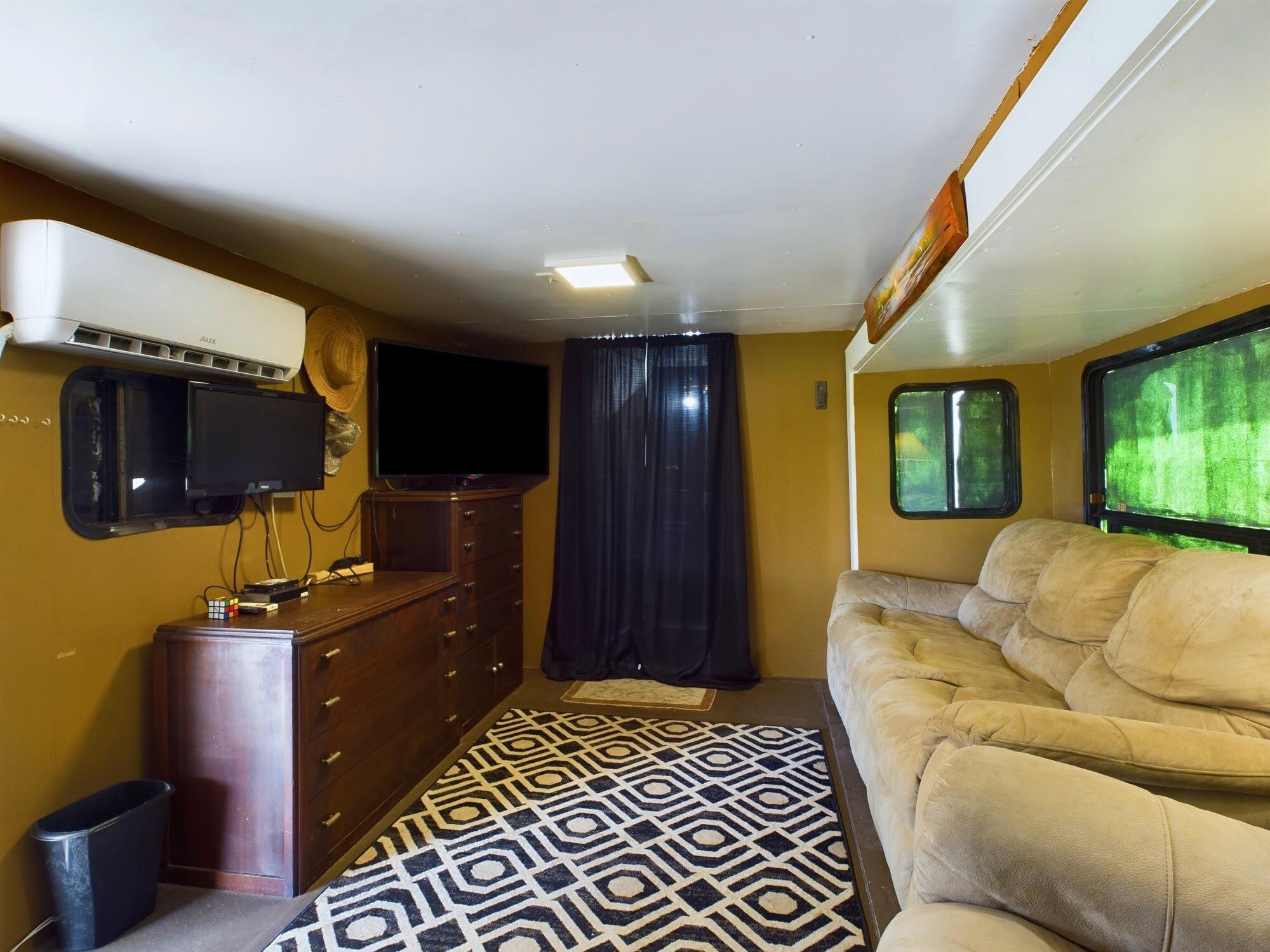 1224001 Holopaw Groves Rd Street St. Cloud, FL 34773 - Photo 63 of 99 a living room with furniture a flat screen tv and kitchen view