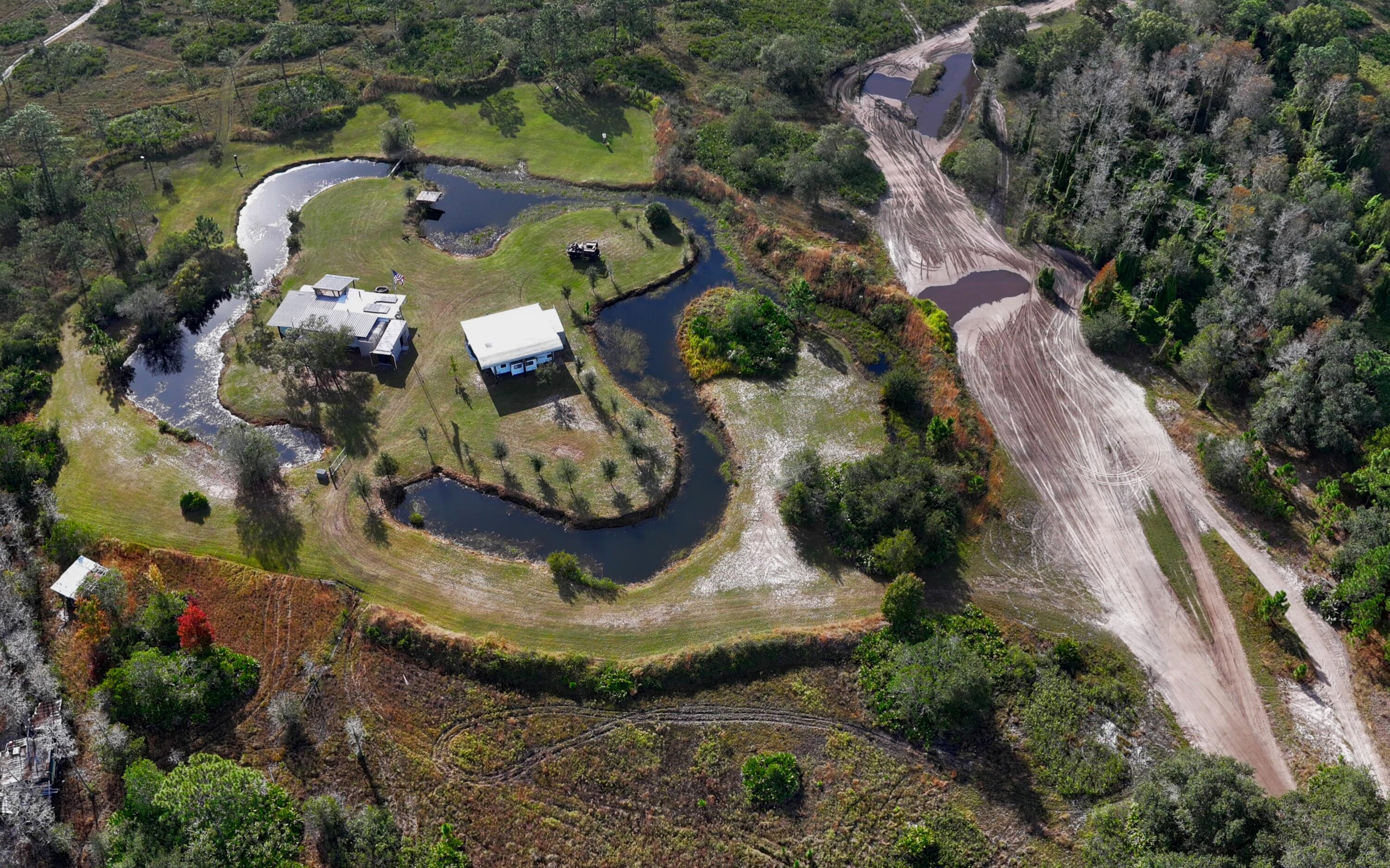 1224001 Holopaw Groves Rd Street St. Cloud, FL 34773 - Photo 82 of 99 an aerial view of a house with a yard and trees
