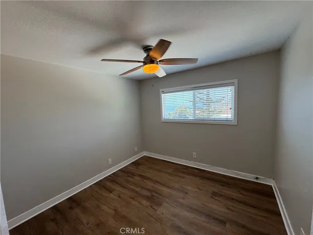 a view of room with hardwood floor and a ceiling fan