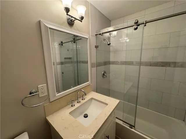a bathroom with a sink mirror and shower
