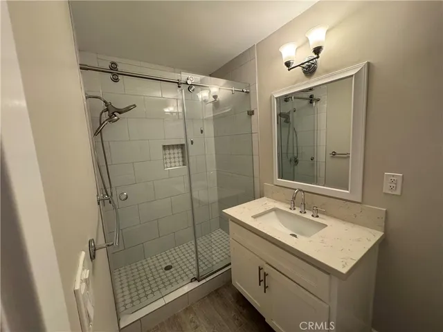 a bathroom with a shower sink and mirror