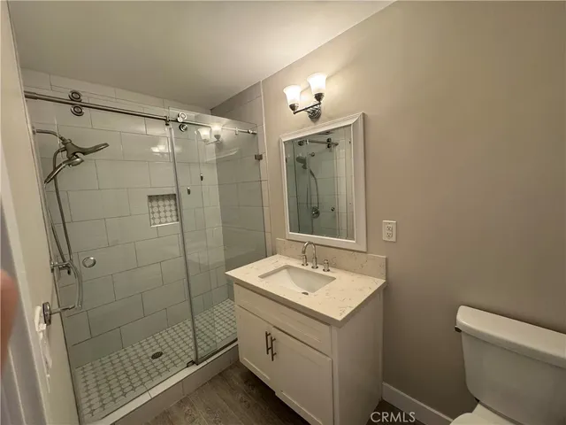 a bathroom with a shower sink mirror and toilet
