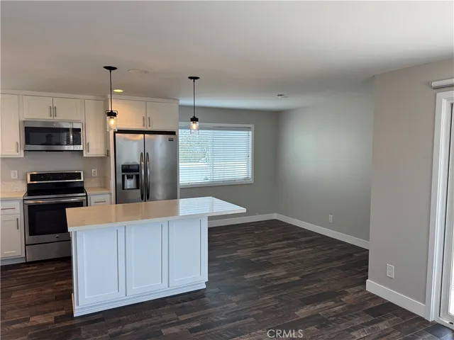 a kitchen with kitchen island white cabinets and stainless steel appliances