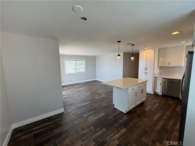 a large kitchen with kitchen island white cabinets and stainless steel appliances