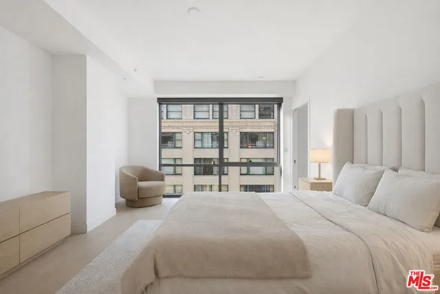 a bedroom with a bed and a large window