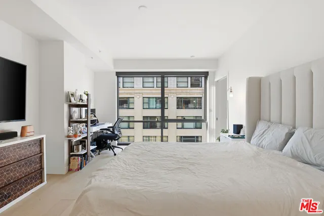 a large bedroom with a bed and a large window