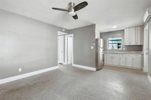 an empty room with a ceiling fan and window