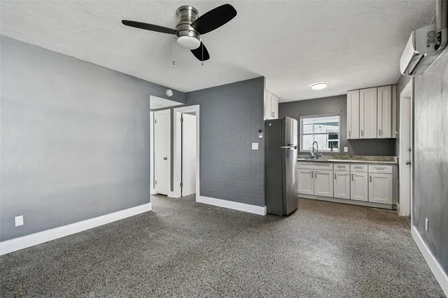 a kitchen with granite countertop a sink stove and refrigerator