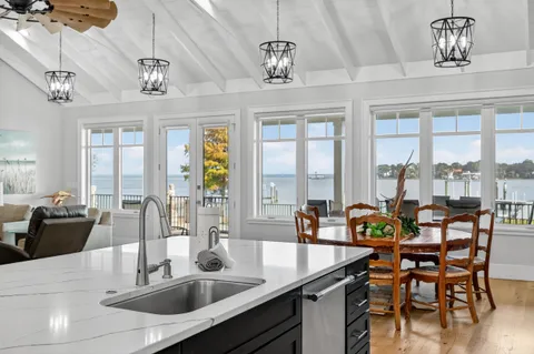 a view of a dining room with furniture large windows and wooden floor