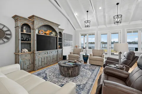 a living room with couches and painting on the wall next to a window