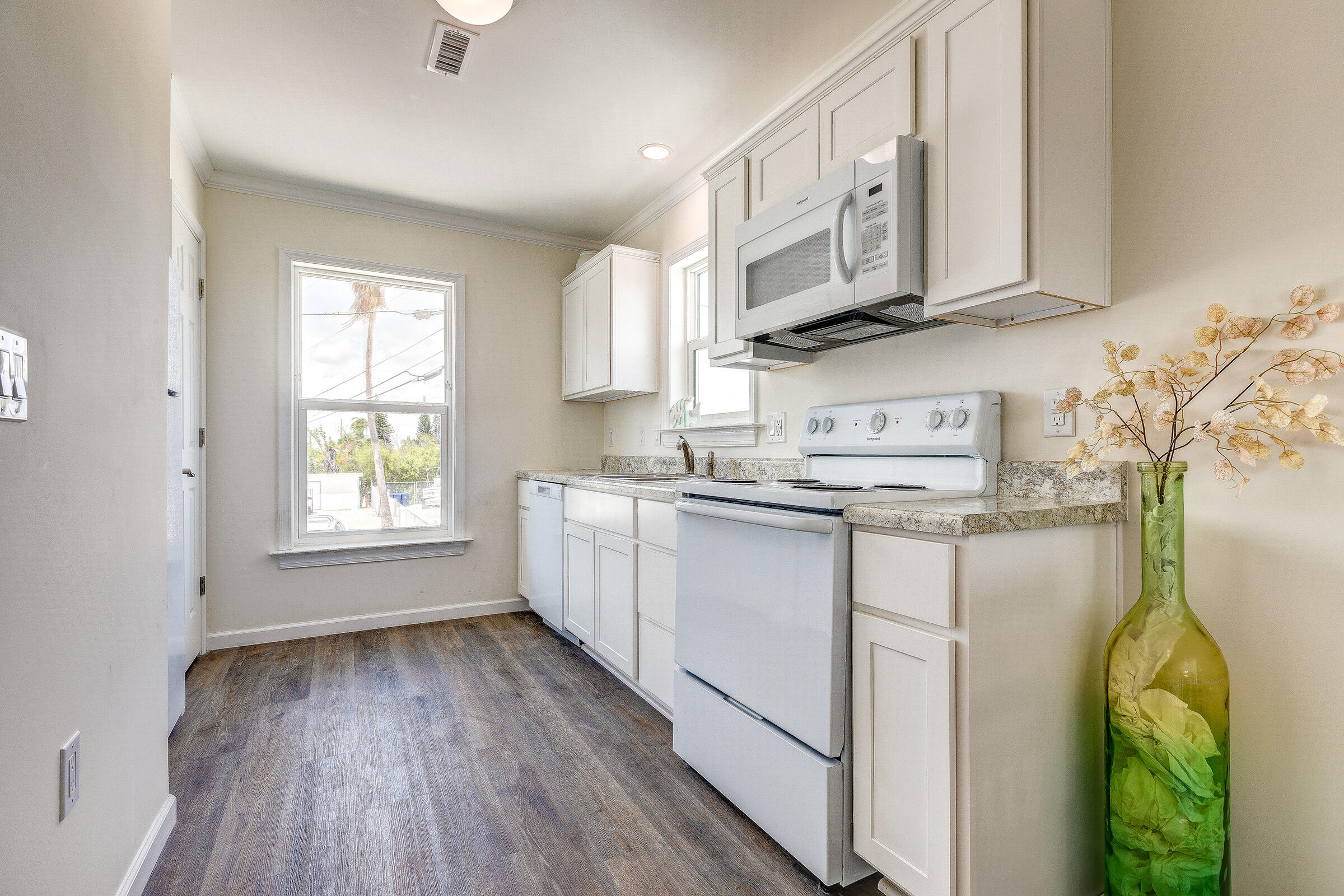 55 Boca Chica Road, Unit 27 Key West, FL 33040 - Photo 10 of 20 a kitchen with stainless steel appliances granite countertop a sink a stove cabinets and wooden floor