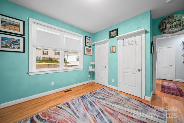 a bedroom with bed and wooden floor