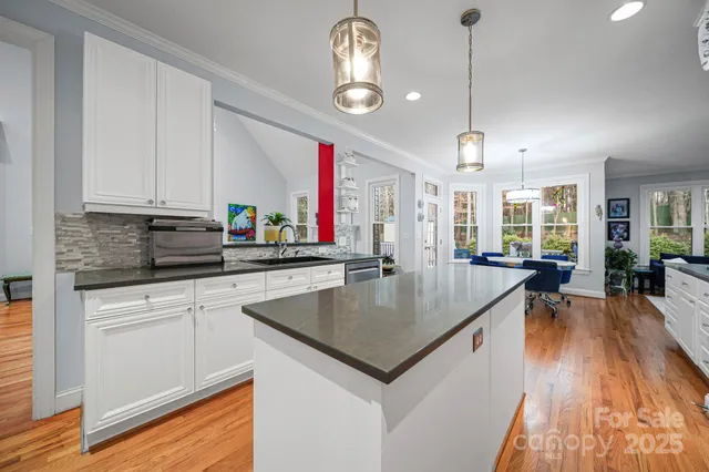 a kitchen with stainless steel appliances granite countertop wooden floors stove top oven and cabinets