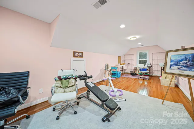 a view of a wooden house with a yard and sitting area