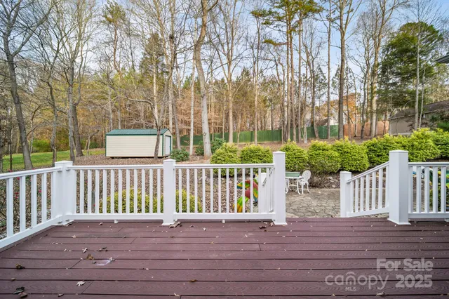 a view of a deck with white chairs and wooden fence