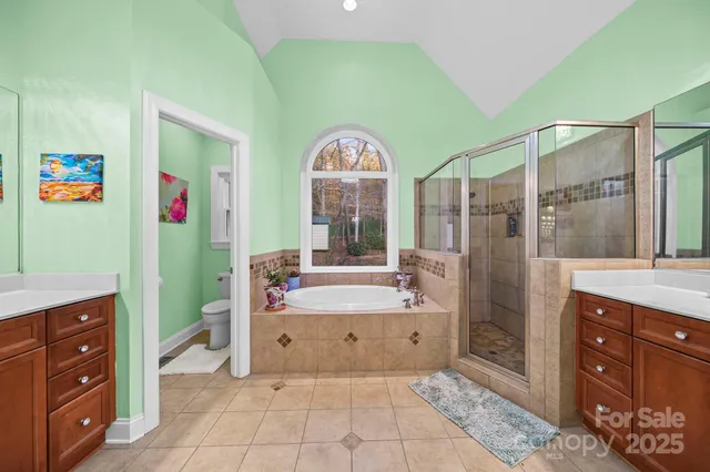 a spacious bathroom with a tub sink and mirror