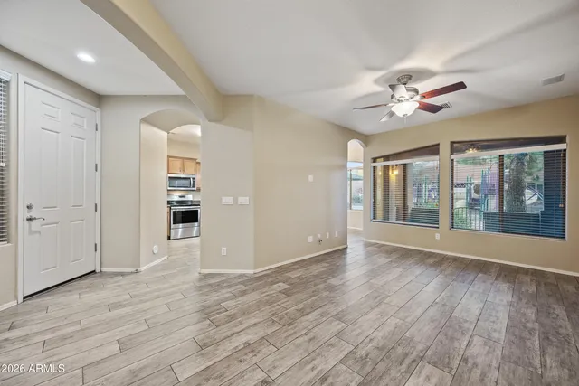 a view of an empty room with a window and wooden floor