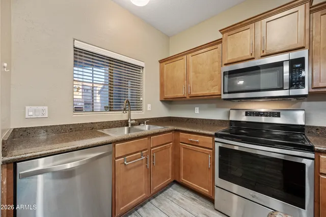 a kitchen with granite countertop cabinets stainless steel appliances and a sink