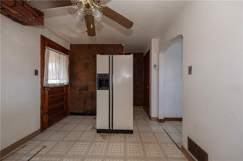 939 Delevan Street Pittsburgh, PA 15217 - Photo 7 of 36 a view of a refrigerator in kitchen and an empty room with wooden floor