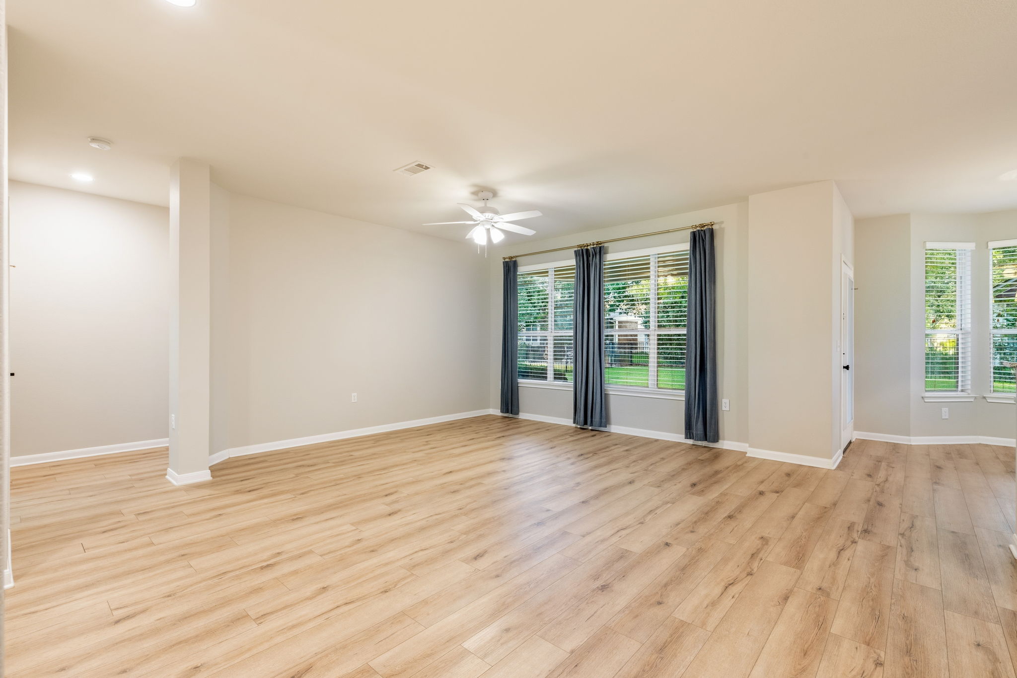 137 Trail Rider Way Georgetown, TX 78633 - Photo 3 of 29 A generously proportioned living space features wood-style flooring and abundant natural light from multiple windows.