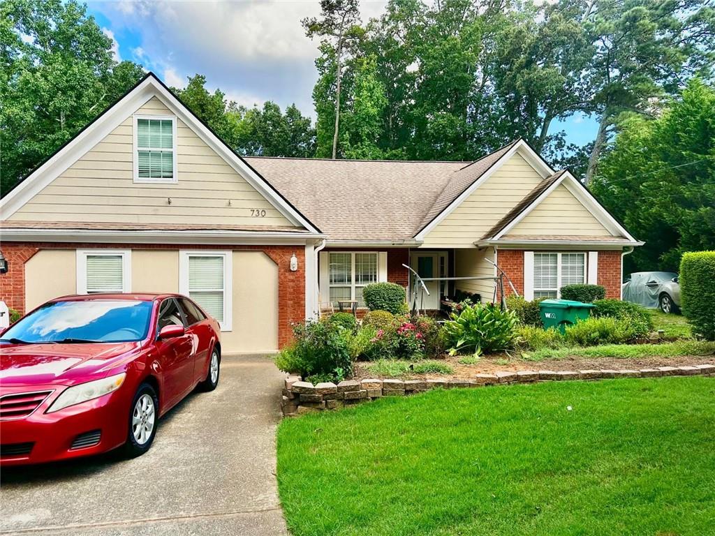 730 Tab Roberts Road Northwest Lawrenceville, GA 30043 - Photo 2 of 6 a front view of a house with a garden and plants