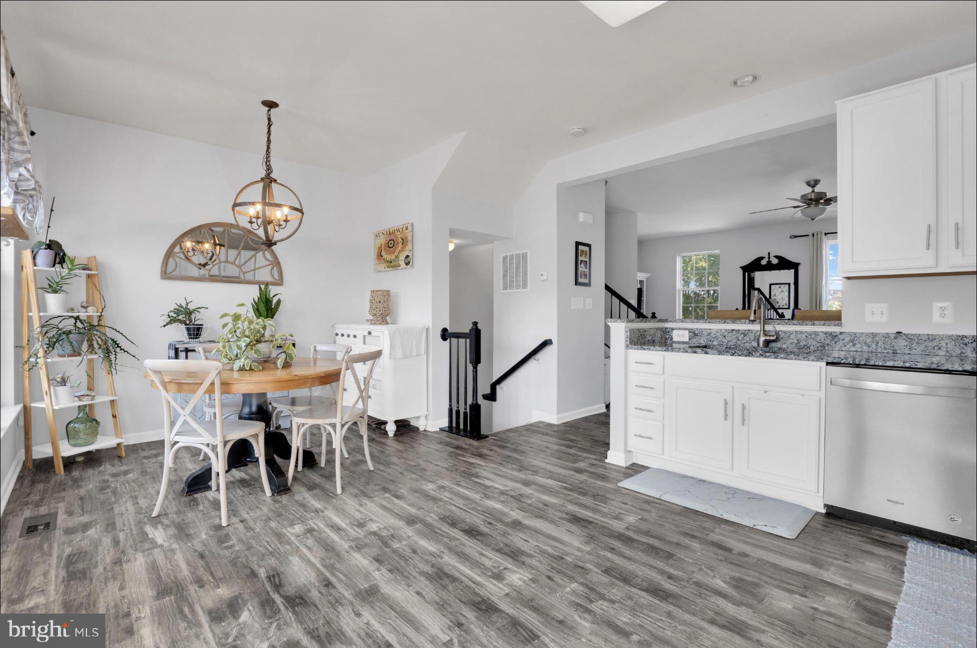 25336 Sweetness Terrace Aldie, VA 20105 - Photo 16 of 33 a dining room with wooden floor a chandelier a wooden table and chairs