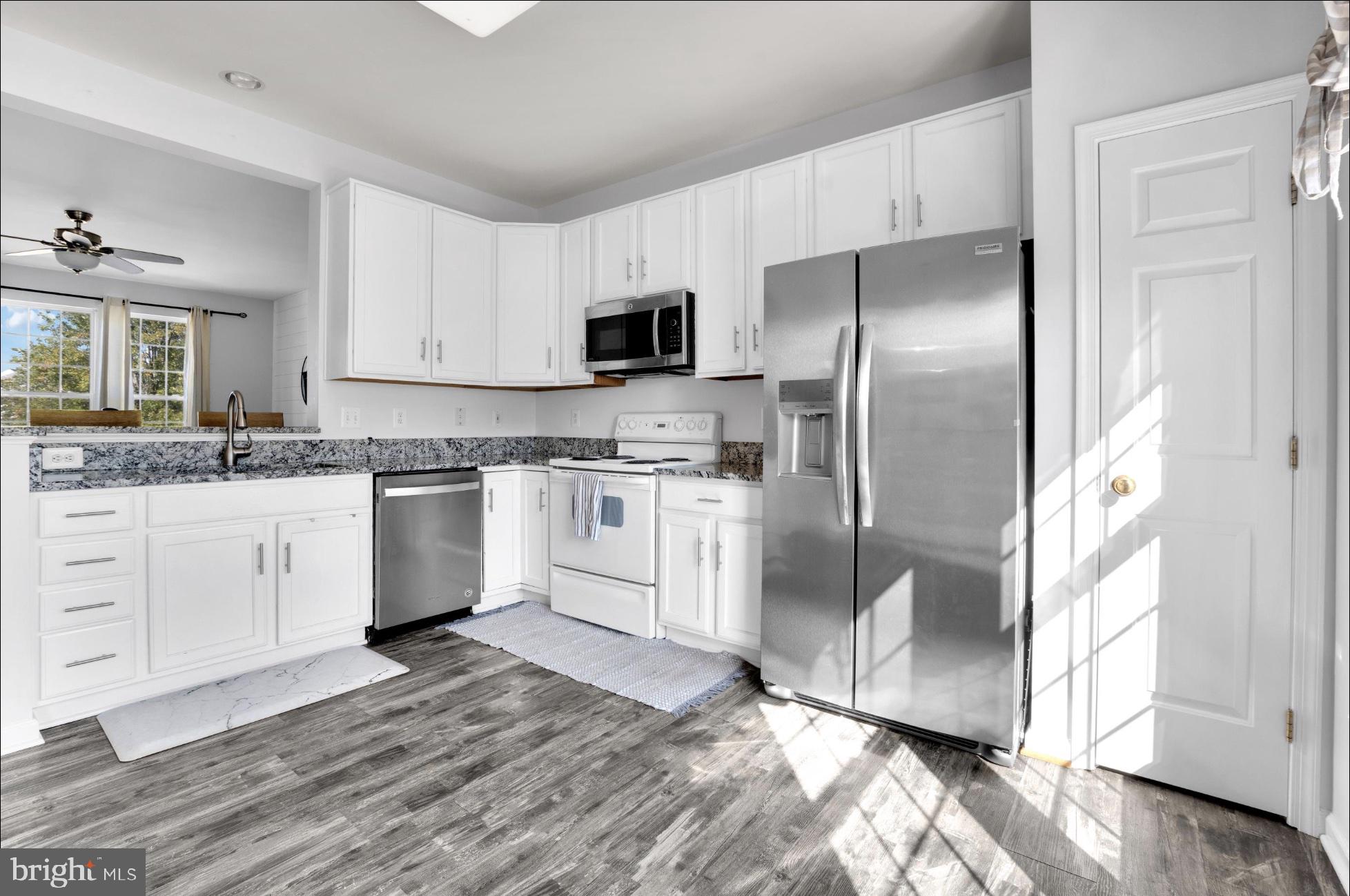 25336 Sweetness Terrace Aldie, VA 20105 - Photo 18 of 33 a kitchen with stainless steel appliances granite countertop a refrigerator sink and white cabinets
