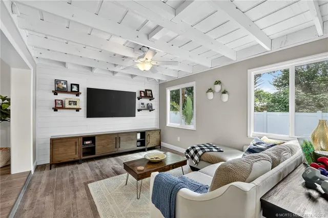 a kitchen with stainless steel appliances granite countertop a stove top oven a sink dishwasher a refrigerator and a dining table with wooden floor