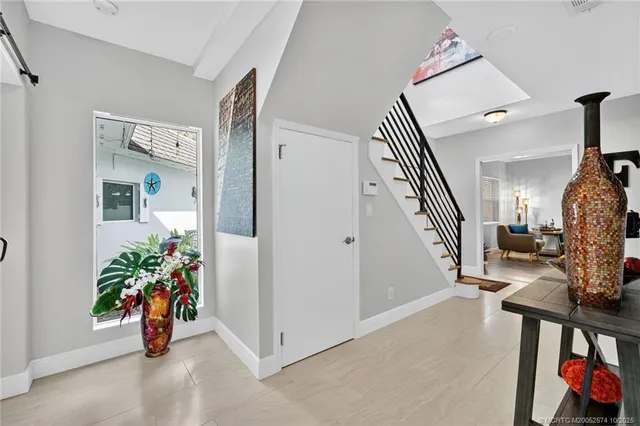 a bedroom with a large bed chandelier and a window