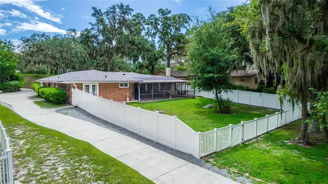 a view of a house with brick walls and a yard with plants