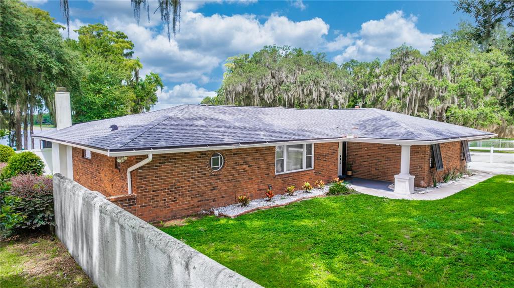 5584 North Dean Road Orlando, FL 32817 - Photo 5 of 39 a view of a house with brick walls and a yard with plants