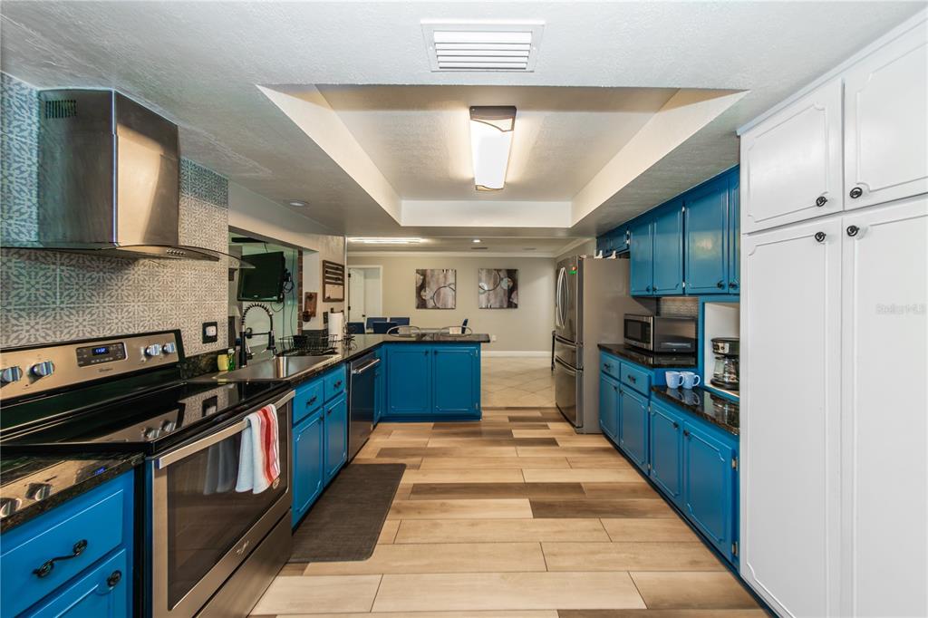 5584 North Dean Road Orlando, FL 32817 - Photo 10 of 39 a large kitchen with stainless steel appliances granite countertop a stove kitchen island a refrigerator and a stove