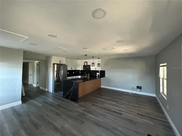 a large kitchen with kitchen island a sink and a refrigerator