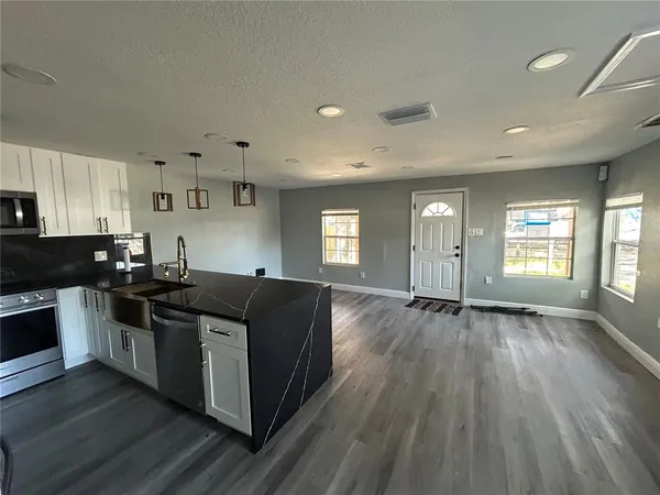a kitchen with stainless steel appliances granite countertop a sink and stove top oven