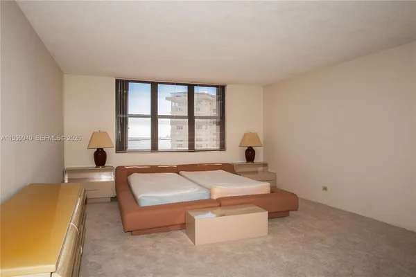 a spacious bedroom with a bed and a large window