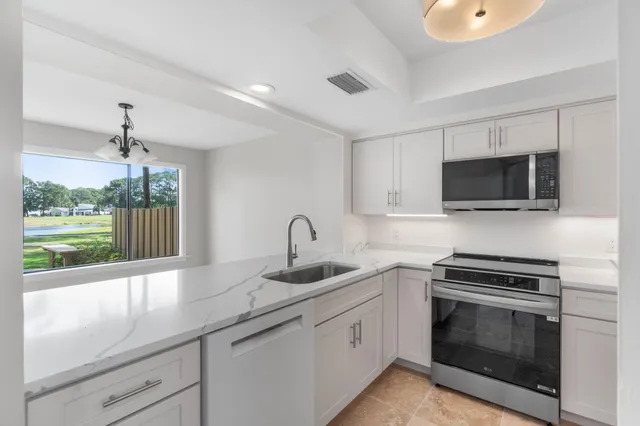 a view of cabinets a sink and a window in a room