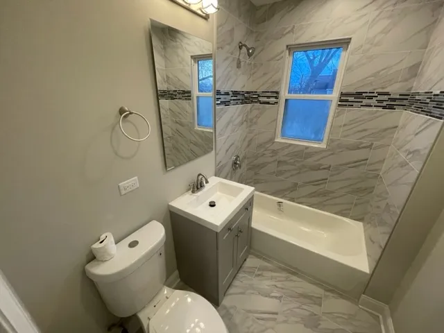 a white toilet sitting next to a bathroom sink