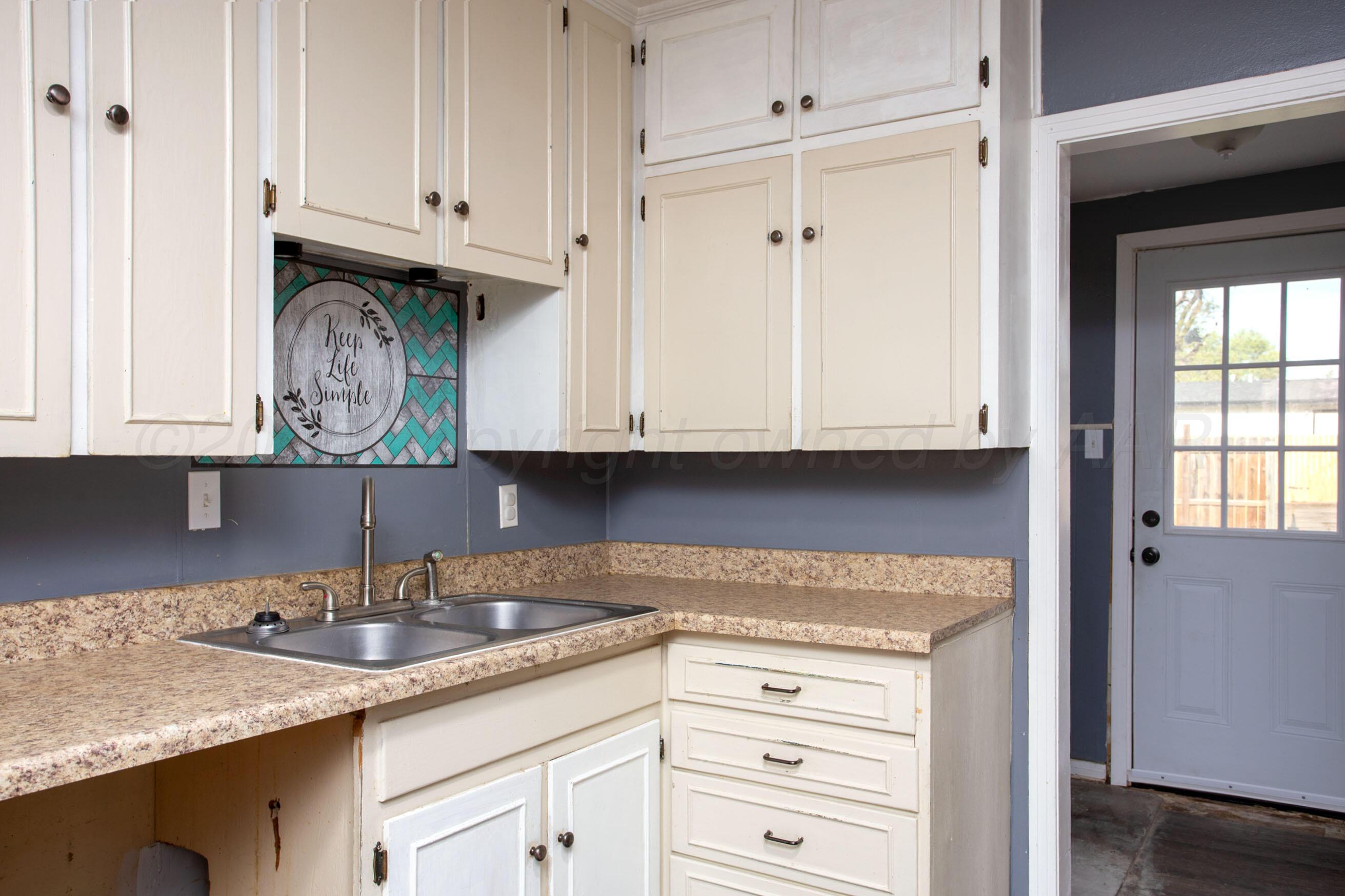 4630 South Hayden Street Amarillo, TX 79110 - Photo 11 of 26 a kitchen with granite countertop white cabinets and sink